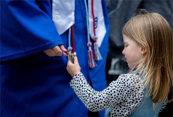 一个小女孩在玩一个毕业生的绳子.
