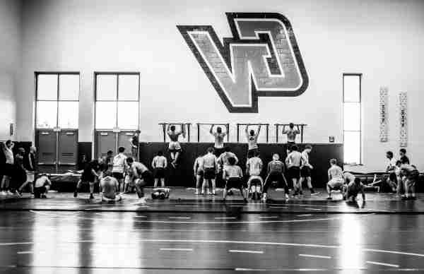 College wrestling athletes workout during practice.  