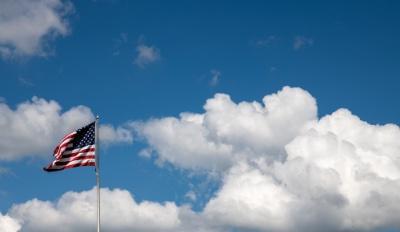 美国国旗飘扬在多云的蓝天上